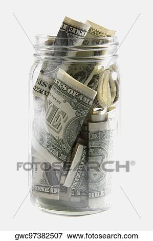 Stock Photo - Dollar bills squashed into a jar. Fotosearch