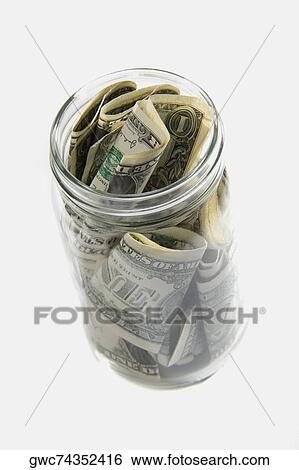 Dollar bills squashed into a jar View Large Photo Image Stock Photograph - Dollar bills squashed into a jar. Fotosearch