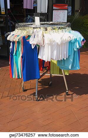 Dresses hanging by a clothes rack outside a clothing store View Large Photo Image Stock Photo - Dresses hanging by a clothes rack outside a clothing store. Fotosearch
