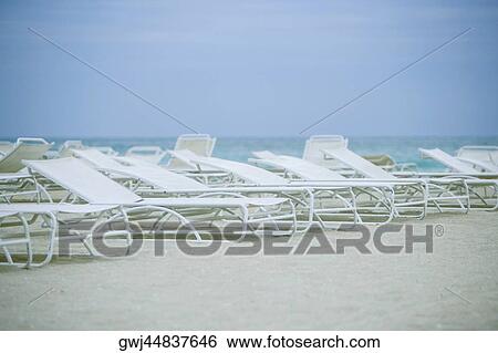 Empty lounge chairs on the beach View Large Photo Image Stock Photograph - Empty lounge chairs on the beach. Fotosearch