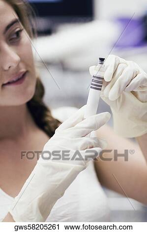 Stock Image - Female doctor holding a syringe. Fotosearch