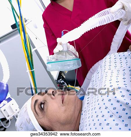Female surgeon putting an oxygen mask on a female patient's face View Large Photo Image Stock Image - Female surgeon putting an oxygen mask on a female patient's face. Fotosearch