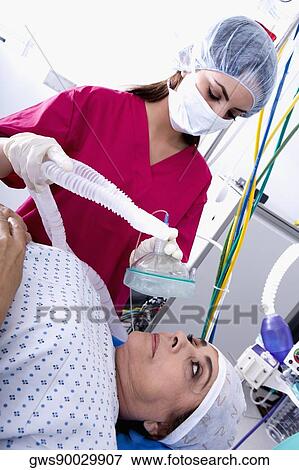 Female surgeon putting an oxygen mask on a female patient's face View Large Photo Image Stock Photo - Female surgeon putting an oxygen mask on a female patient's face. Fotosearch