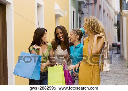 Four teenage girls holding shopping bags and laughing View Large Photo Image Stock Photography - Four teenage girls holding shopping bags and laughing. Fotosearch