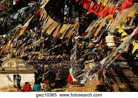 Stock Photography - Group of people sitting under prayer flags, Monkey Temple, Katmandu, Nepal. Fotosearch