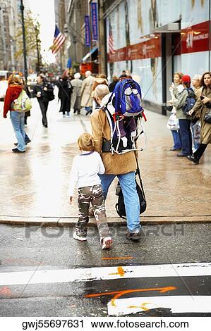 Group of people walking on the sidewalk View Large Photo Image Stock Image - Group of people walking on the sidewalk. Fotosearch