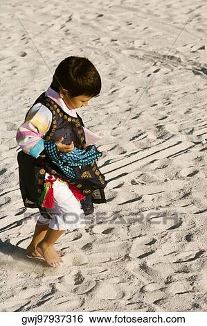 Stock Photograph - High angle view of a boy walking on the sand. Fotosearch