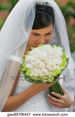High angle view of a bride smelling a bouquet of flowers View Large Photo Image Stock Photo - High angle view of a bride smelling a bouquet of flowers. Fotosearch