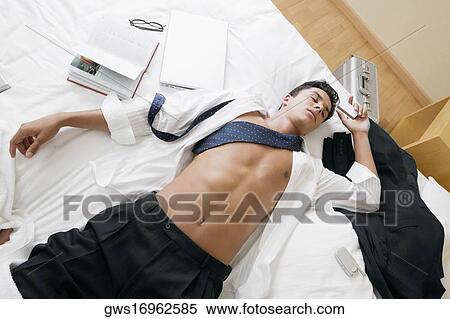 Stock Photography - High angle view of a businessman sleeping on the bed. Fotosearch