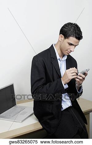 Stock Photography - High angle view of a businessman using a personal data assistant. Fotosearch