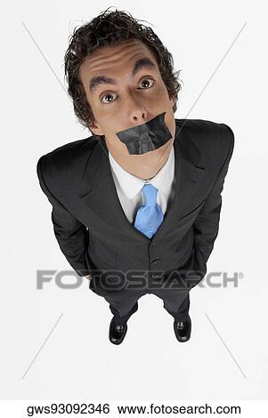 Stock Photograph - High angle view of a businessman with duct tape on his mouth. Fotosearch