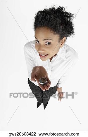Stock Image - High angle view of a businesswoman showing a compass. Fotosearch