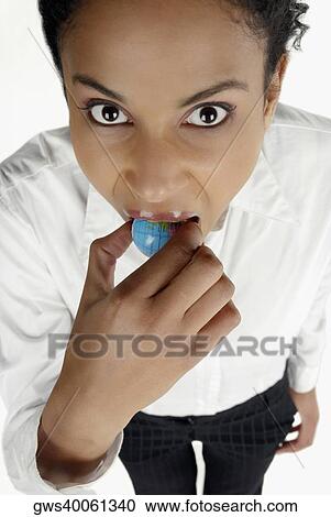 High angle view of a businesswoman holding a globe in her mouth View Large Photo Image Stock Image - High angle view of a businesswoman holding a globe in her mouth. Fotosearch