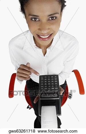 Stock Photo - High angle view of a businesswoman holding an adding machine tape and smiling. Fotosearch
