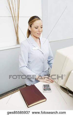 High angle view of a female receptionist using a computer View Large Photo Image Stock Photo - High angle view of a female receptionist using a computer. Fotosearch