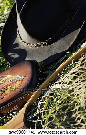 Stock Photography - High angle view of a fishing net and a cowboy hat on the lawn. Fotosearch