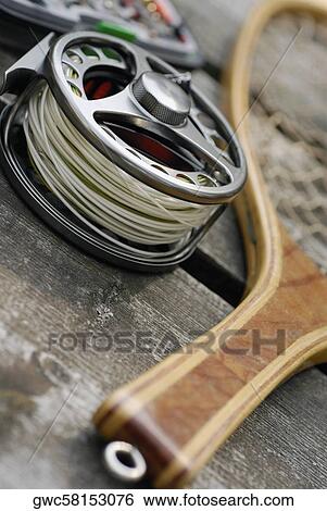 Stock Photograph - High angle view of a fishing reel and a fishing net. Fotosearch