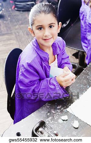 High angle view of a girl sitting at the table and holding a bottle of talcum powder View Large Photo Image Stock Image - High angle view of a girl sitting at the table and holding a bottle of talcum powder. Fotosearch