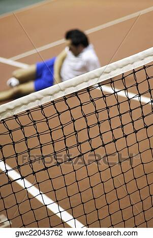 High angle view of a mid adult man reclining on a tennis court View Large Photo Image Stock Image - High angle view of a mid adult man reclining on a tennis court. Fotosearch