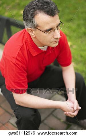 High angle view of a mid adult man sitting on a bench View Large Photo Image Stock Photograph - High angle view of a mid adult man sitting on a bench. Fotosearch