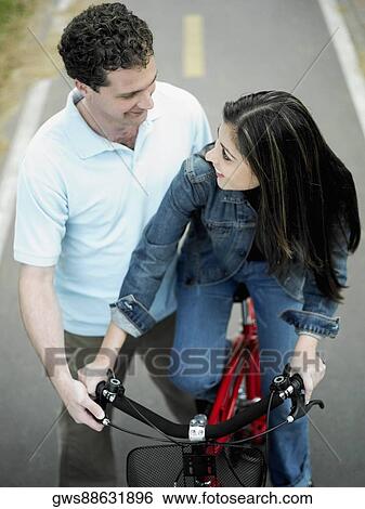 High angle view of a mid adult man helping a mid adult woman ride a bicycle View Large Photo Image Stock Photograph - High angle view of a mid adult man helping a mid adult woman ride a bicycle. Fotosearch