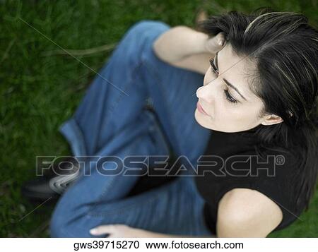 High angle view of a mid adult woman sitting on a lawn View Large Photo Image Stock Image - High angle view of a mid adult woman sitting on a lawn. Fotosearch
