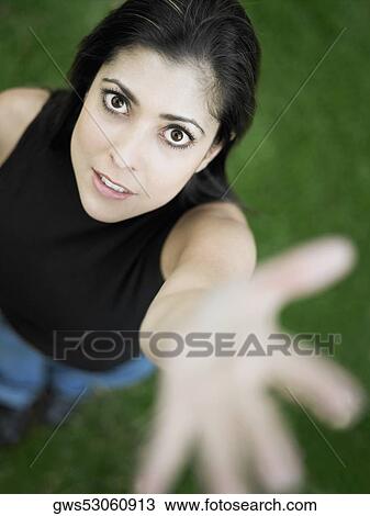 High angle view of a mid adult woman standing with her hand raised View Large Photo Image Stock Image - High angle view of a mid adult woman standing with her hand raised. Fotosearch