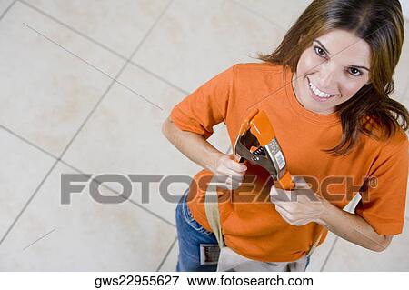 High angle view of a mid adult woman holding a clamp and smiling View Large Photo Image Stock Photo - High angle view of a mid adult woman holding a clamp and smiling. Fotosearch