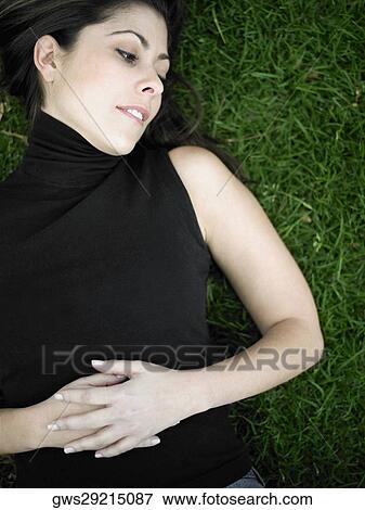 High angle view of a mid adult woman lying on a lawn View Large Photo Image Stock Photo - High angle view of a mid adult woman lying on a lawn. Fotosearch
