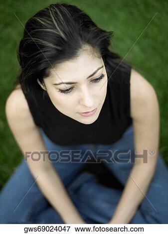 High angle view of a mid adult woman sitting on a lawn View Large Photo Image Stock Photo - High angle view of a mid adult woman sitting on a lawn. Fotosearch