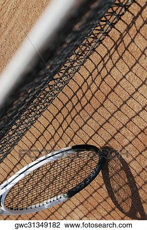 Stock Image - High angle view of a tennis racket and a tennis net. Fotosearch