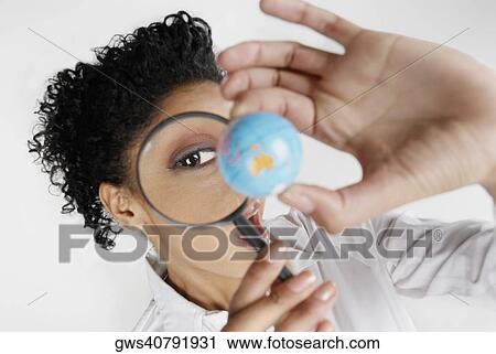 High angle view of a young woman scrutinizing a globe with a magnifying glass View Large Photo Image Stock Image - High angle view of a young woman scrutinizing a globe with a magnifying glass. Fotosearch