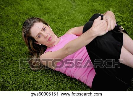 Stock Image - High angle view of a young woman exercising in a park. Fotosearch