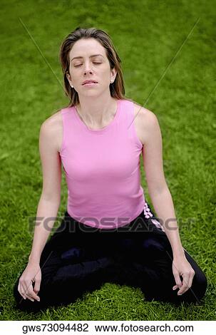 High angle view of a young woman sitting in the lotus position View Large Photo Image Stock Image - High angle view of a young woman sitting in the lotus position. Fotosearch