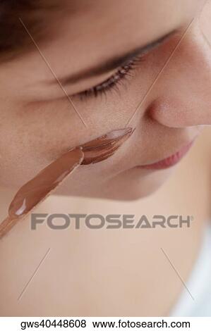High angle view of a young woman applying a facial mask on her face View Large Photo Image Stock Photo - High angle view of a young woman applying a facial mask on her face. Fotosearch