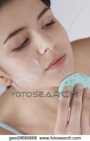 High angle view of a young woman scrubbing her chin with a sponge View Large Photo Image Stock Photo - High angle view of a young woman scrubbing her chin with a sponge. Fotosearch