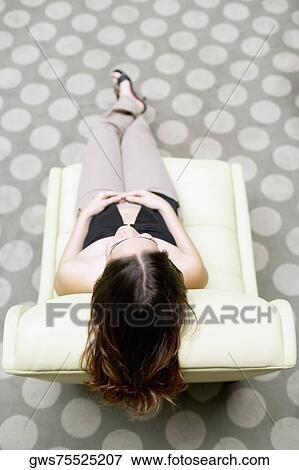 High angle view of a young woman sitting on a chair View Large Photo Image Stock Photo - High angle view of a young woman sitting on a chair. Fotosearch