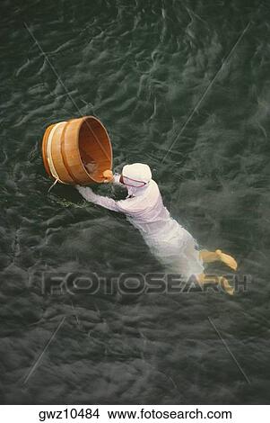 High angle view of an Ama diver with a basket in the sea, Mikimoto Pearl Island, Toba, Mie Prefecture, Japan View Large Photo Image Picture - High angle view of an Ama diver with a basket in the sea, Mikimoto Pearl Island, Toba, Mie Prefecture, Japan. Fotosearch