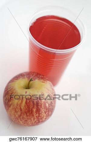High angle view of an apple with a glass of juice View Large Photo Image Stock Photo - High angle view of an apple with a glass of juice. Fotosearch