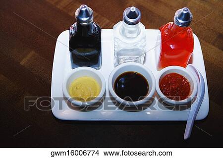 High angle view of bowls of soups with sauce bottles on a tray View Large Photo Image Picture - High angle view of bowls of soups with sauce bottles on a tray. Fotosearch