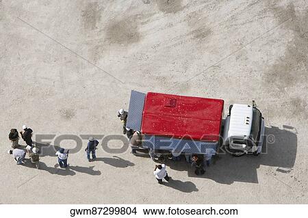 High angle view of construction workers standing near a semi truck View Large Photo Image Picture - High angle view of construction workers standing near a semi truck. Fotosearch