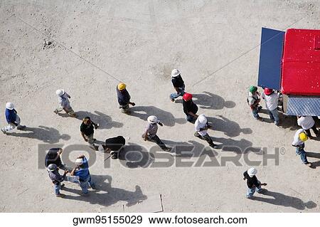 Stock Photo - High angle view of construction workers near a semi truck. Fotosearch