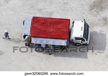 High angle view of construction workers standing near a semi truck View Large Photo Image Stock Photograph - High angle view of construction workers standing near a semi truck. Fotosearch