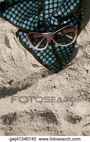 High angle view of sunglasses with a towel on the sand View Large Photo Image Stock Image - High angle view of sunglasses with a towel on the sand. Fotosearch