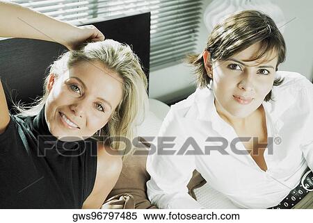 High angle view of two mid adult women reclining on the bed View Large Photo Image Stock Photography - High angle view of two mid adult women reclining on the bed. Fotosearch