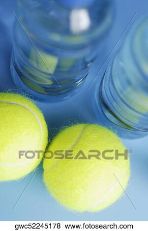 Stock Photo - High angle view of two tennis balls with two water bottles. Fotosearch