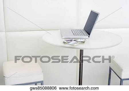 Stock Photograph - Laptop with dollar bill on the table. Fotosearch