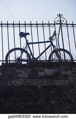 Low angle view of a bicycle leaning against a railing View Large Photo Image Stock Image - Low angle view of a bicycle leaning against a railing. Fotosearch