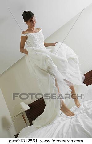 Low angle view of a bride jumping on the bed View Large Photo Image Stock Image - Low angle view of a bride jumping on the bed. Fotosearch