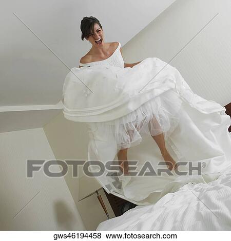 Low angle view of a bride jumping on the bed View Large Photo Image Stock Photo - Low angle view of a bride jumping on the bed. Fotosearch